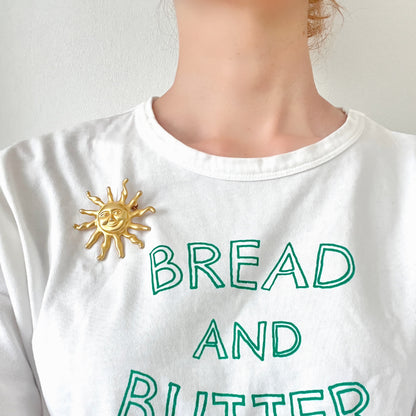 A charming vintage sun brooch featuring a smiling golden face. 微笑みをたたえたゴールドトーンの太陽が印象的なヴィンテージブローチ。