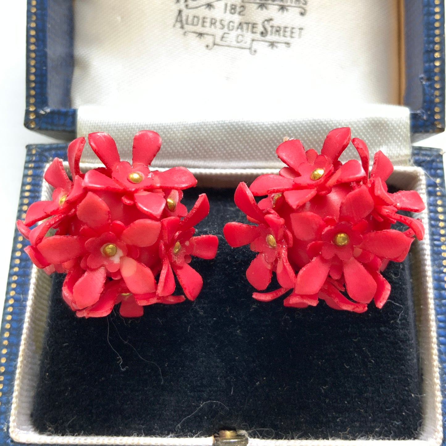 A charming pair of 1960s screw back earrings from Czechoslovakia, featuring vibrant red plastic flowers arranged in a beautiful three-dimensional cluster. 赤いお花の1960年代のチェコスロヴァキアのヴィンテージスクリューイヤリング。