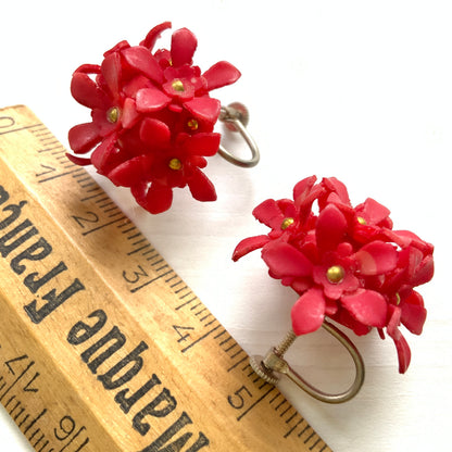 A charming pair of 1960s screw back earrings from Czechoslovakia, featuring vibrant red plastic flowers arranged in a beautiful three-dimensional cluster. 赤いお花の1960年代のチェコスロヴァキアのヴィンテージスクリューイヤリング。