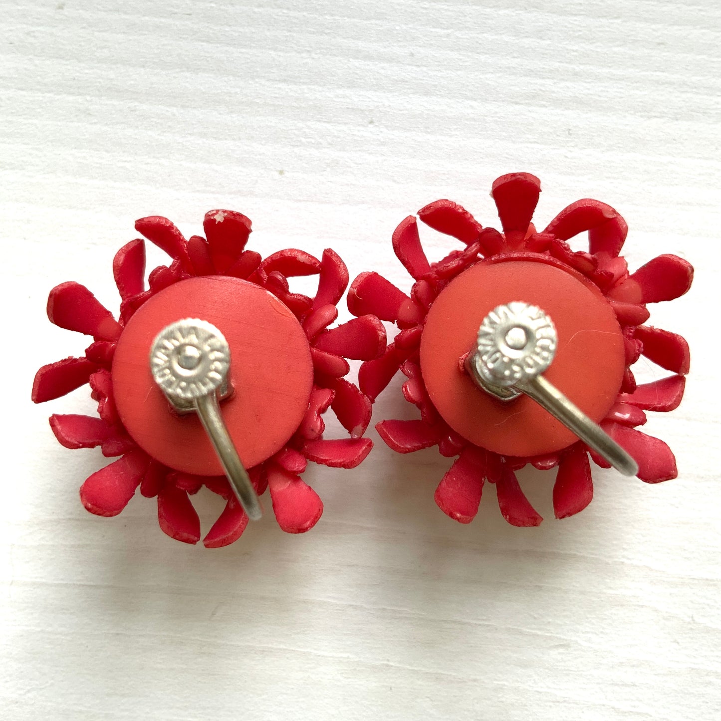 A charming pair of 1960s screw back earrings from Czechoslovakia, featuring vibrant red plastic flowers arranged in a beautiful three-dimensional cluster. 赤いお花の1960年代のチェコスロヴァキアのヴィンテージスクリューイヤリング。