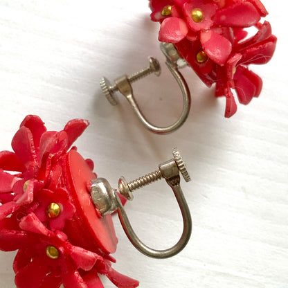 A charming pair of 1960s screw back earrings from Czechoslovakia, featuring vibrant red plastic flowers arranged in a beautiful three-dimensional cluster. 赤いお花の1960年代のチェコスロヴァキアのヴィンテージスクリューイヤリング。