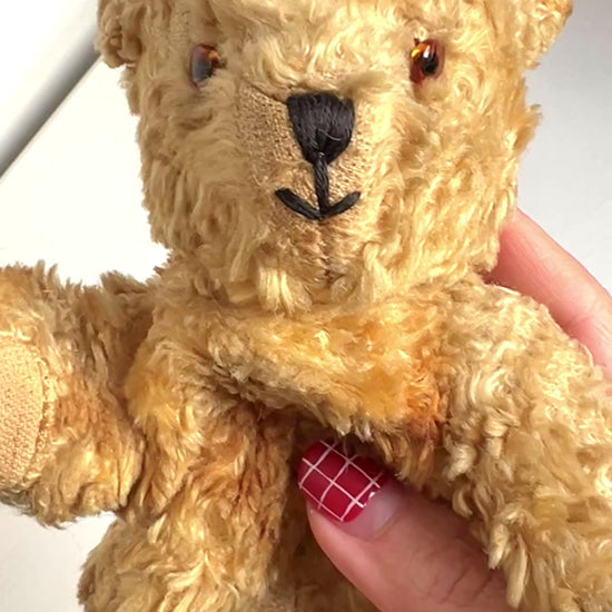 A small vintage teddy bear with the sweetest little smiling mouth.Softened by time, with slightly shrunken stuffing — all part of its charm. 小さな口元がにっこりと微笑んでいる、小さなヴィンテージテディベア。